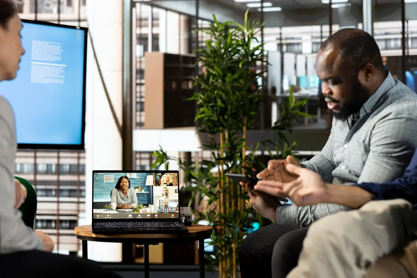 Мужчина проводит видеозвонок с коллегами в офисе компании.